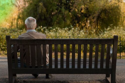 pessoa sentada sozinha em um banco isolada