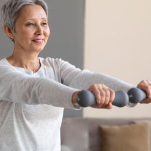 Mulher idosa levantando peso leve em uma academia, simbolizando o treino de força adaptado.